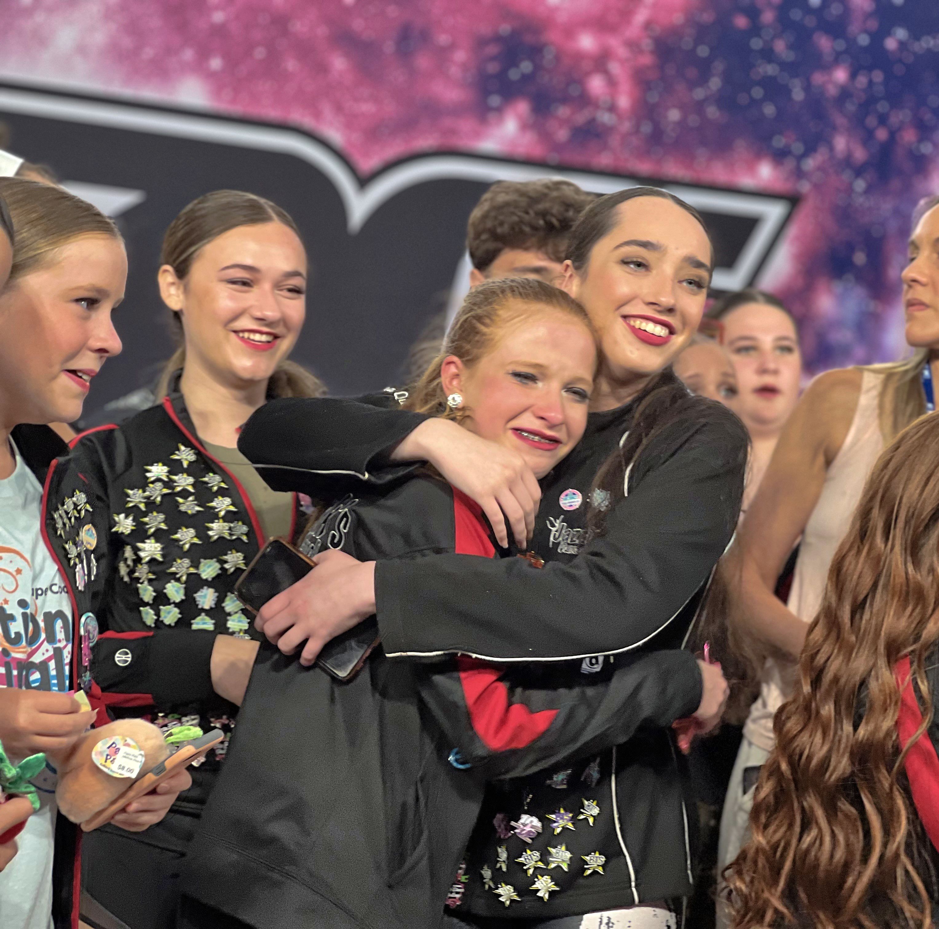 Dance team celebrating competition success with medals and awards